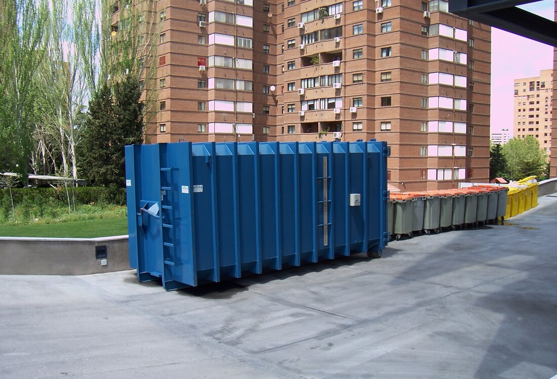 A residential roll off dumpster outside an apartment building